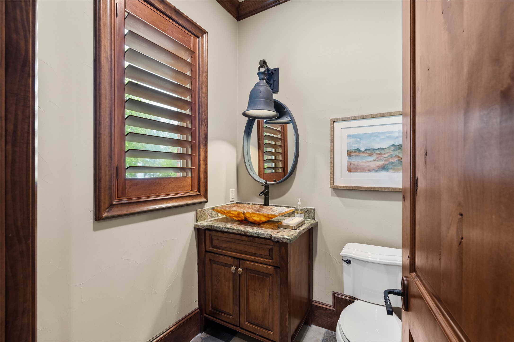 12349 Longmire Trace Conroe, TX 77304 - Photo 17 of 48 Powder bath features rich wood cabinetry, vessel sink, stone countertop, and classic shutters.