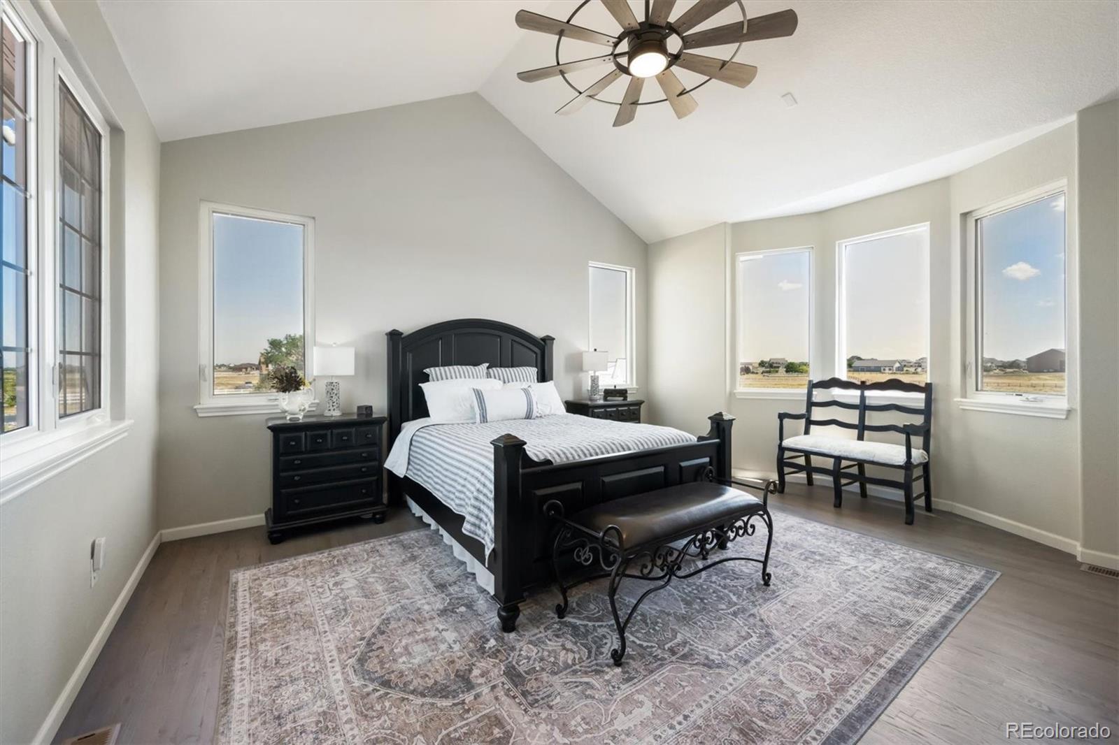 724 Imboden Road Watkins, CO 80137 - Photo 18 of 50 a bedroom with a bed and a chandelier