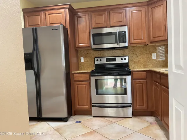 a kitchen with a refrigerator stove and microwave