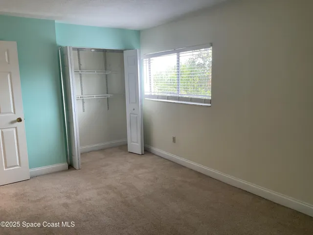 an empty room with windows and closet