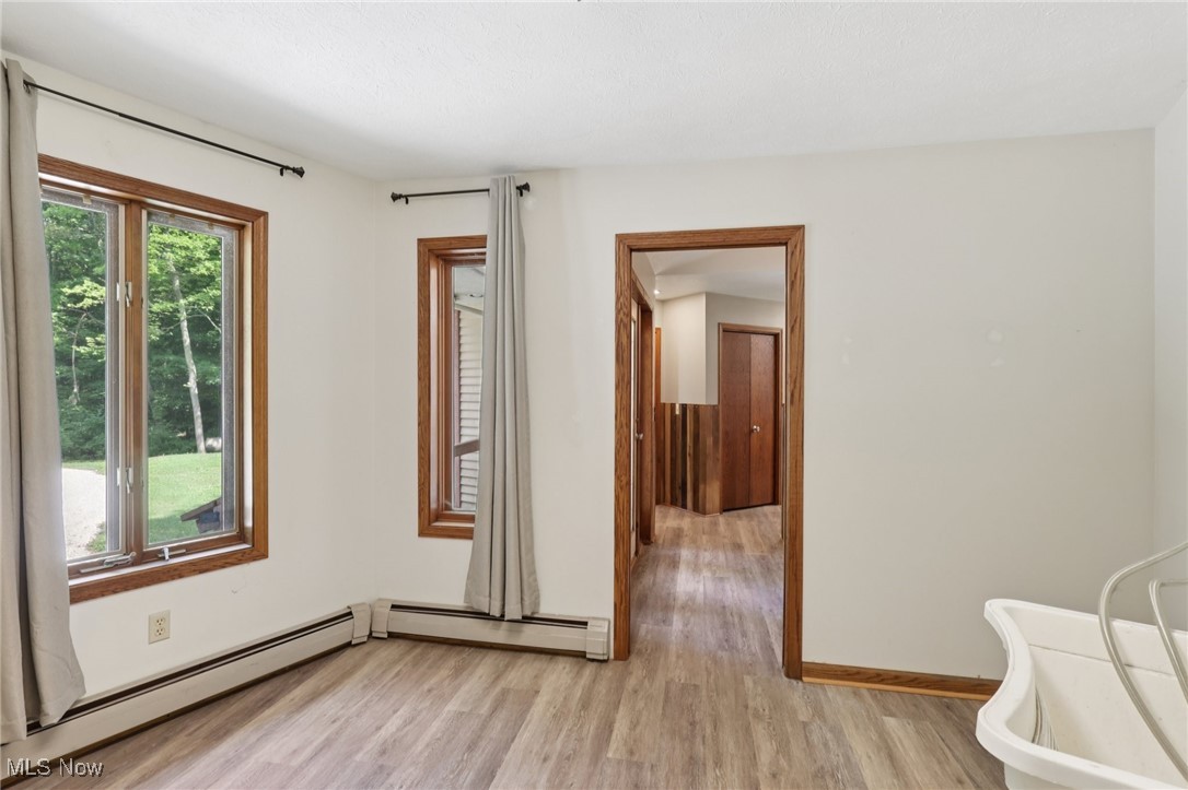 5643 Chapin Road Madison, OH 44057 - Photo 38 of 50 Spare room featuring light wood-style flooring and a baseboard heating unit