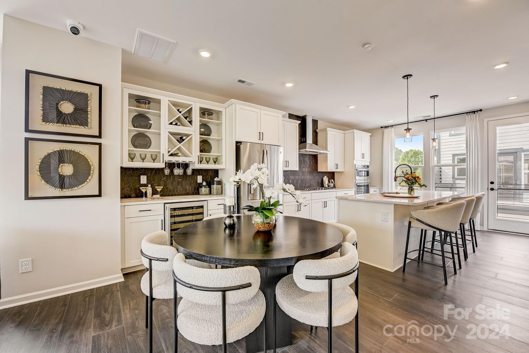 109 Goodson Place Davidson, NC 28036 - Photo 18 of 40 a kitchen with stainless steel appliances granite countertop a dining table chairs and white cabinets