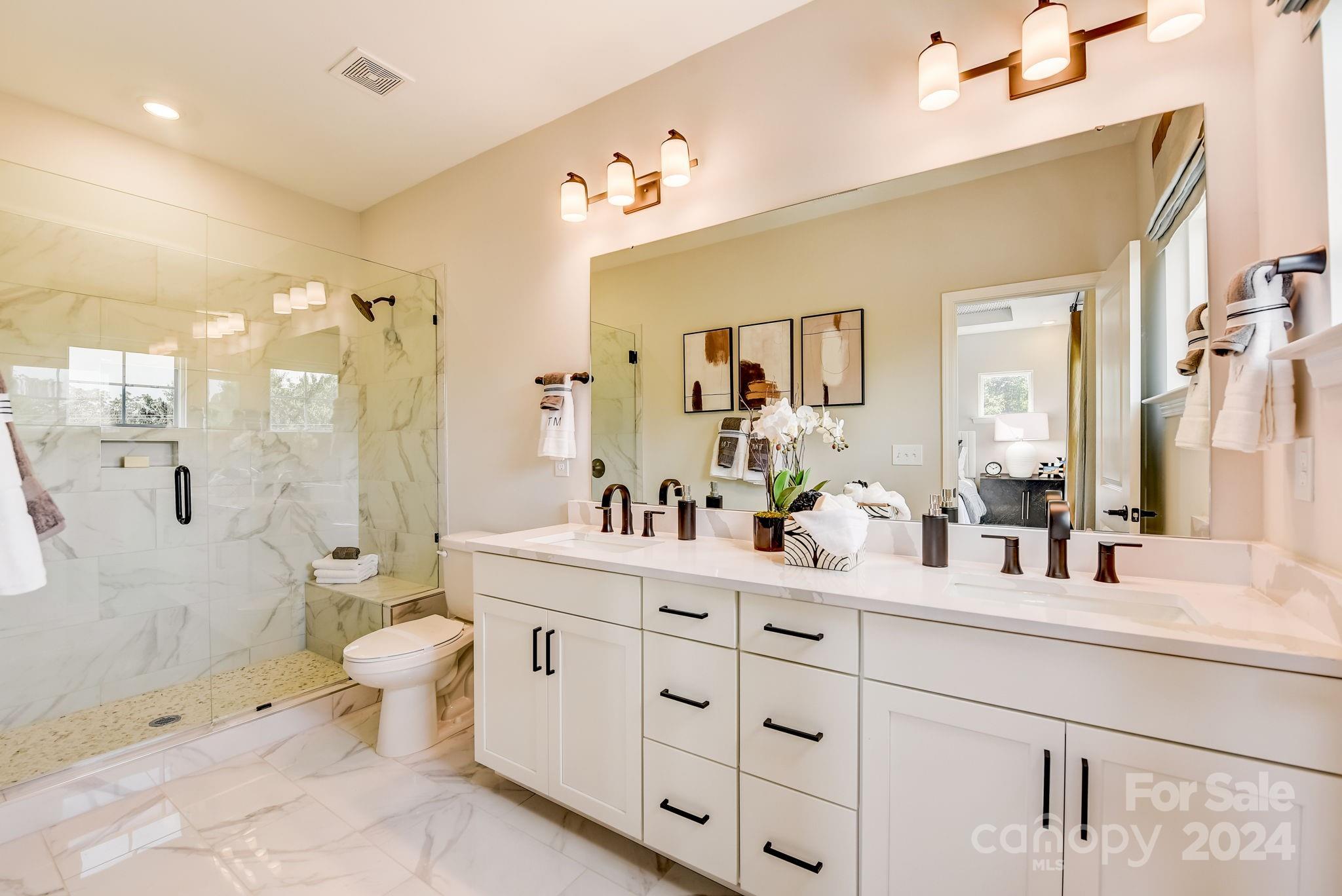 109 Goodson Place Davidson, NC 28036 - Photo 28 of 40 a bathroom with a double vanity sink toilet mirror and shower