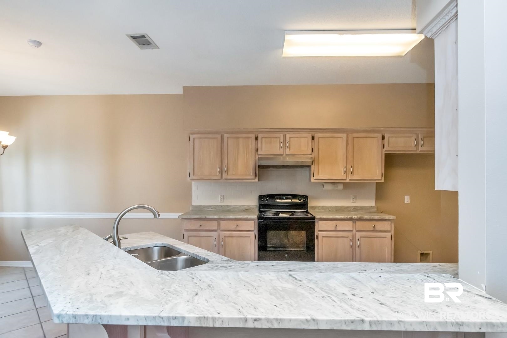 6117 Lennox Place Mobile, AL 36693 - Photo 12 of 39 Kitchen featuring light brown cabinetry, a sink, black range with electric cooktop, under cabinet range hood, and visible vents