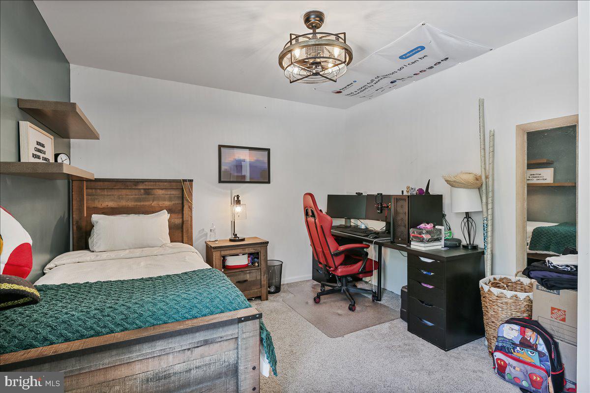 201 Prancer Road Egg Harbor Township, NJ 08234 - Photo 39 of 66 a bedroom with a bed and a chandelier