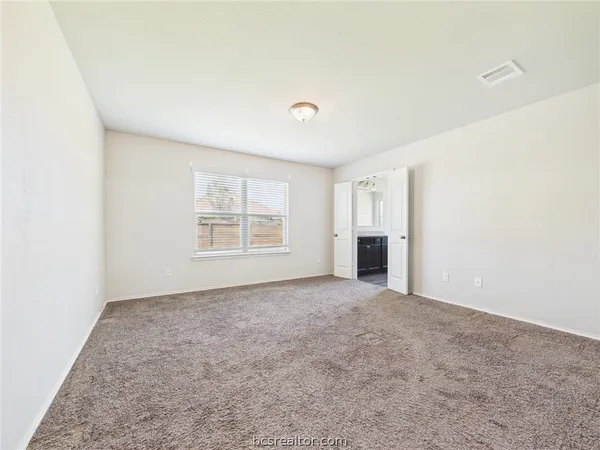 an empty room with a fireplace and window