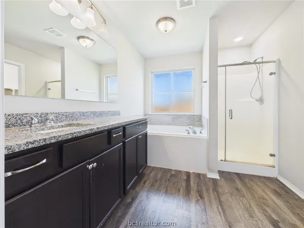 a kitchen with a sink granite counter tops and a wooden floor
