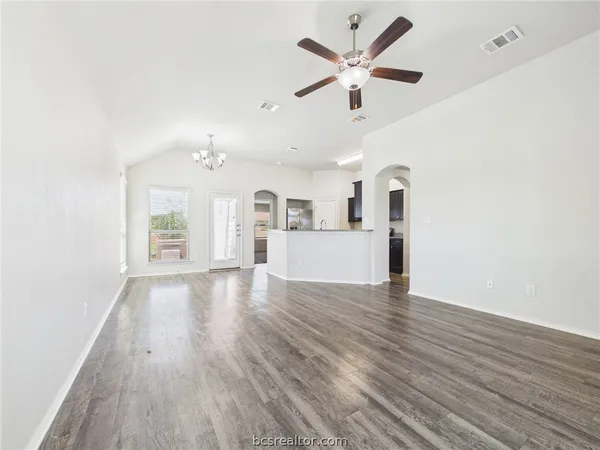 a view of a kitchen with wooden floor and a ceiling fan