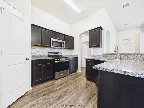 a kitchen with a sink appliances and cabinets