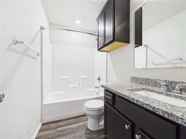 a bathroom with a granite countertop sink toilet and shower