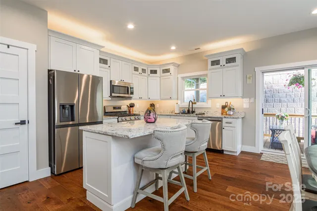 a kitchen with a refrigerator a stove a sink dishwasher with a dining table and chairs