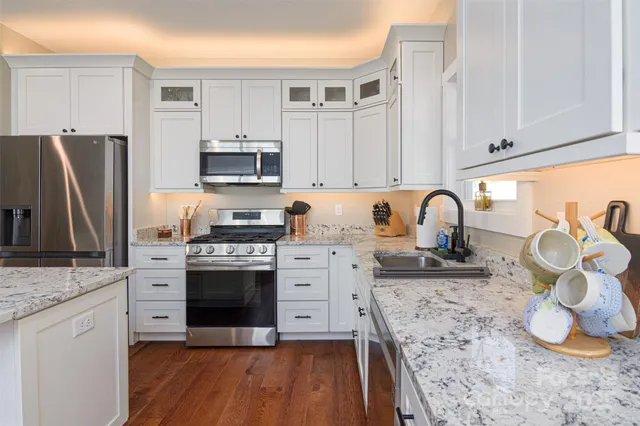 a kitchen with granite countertop a stove and a sink