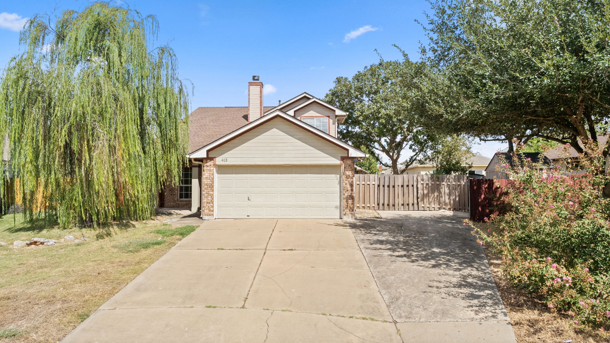 413 Clarks Way Hutto, TX 78634 - Photo 1 of 1 View of front of home featuring driveway, a chimney, an attached garage, and brick siding