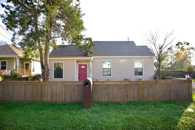 a front view of a house with yard and tree
