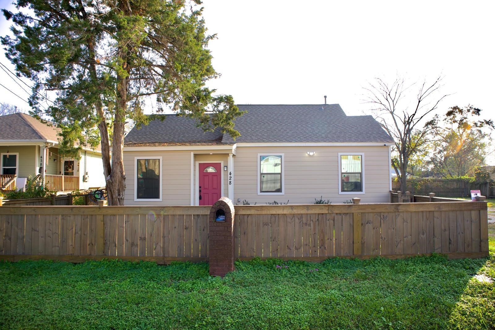 a front view of a house with yard and tree
