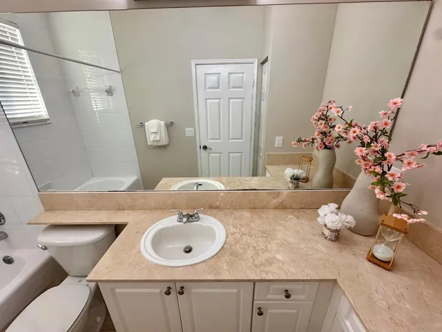 a bathroom with a sink vanity granite and a mirror