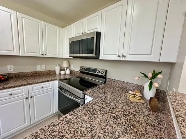 a kitchen with a stove a sink and a white cabinets