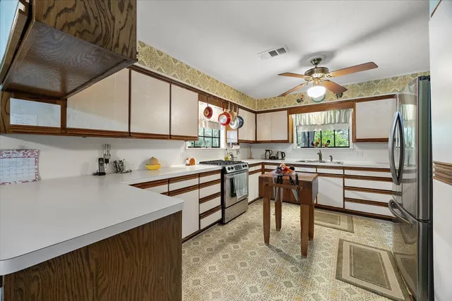a kitchen with stainless steel appliances granite countertop a sink a stove and cabinets
