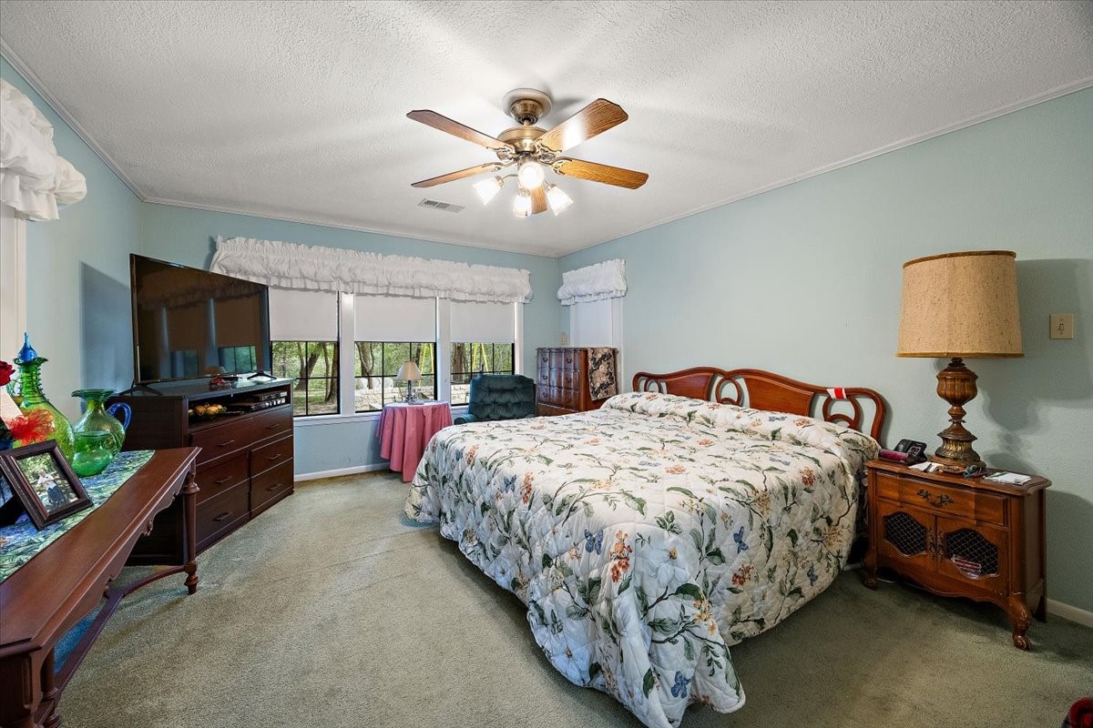 450 Four Notch Road Huntsville, TX 77340 - Photo 17 of 49 a bed room with a bed and a lamp