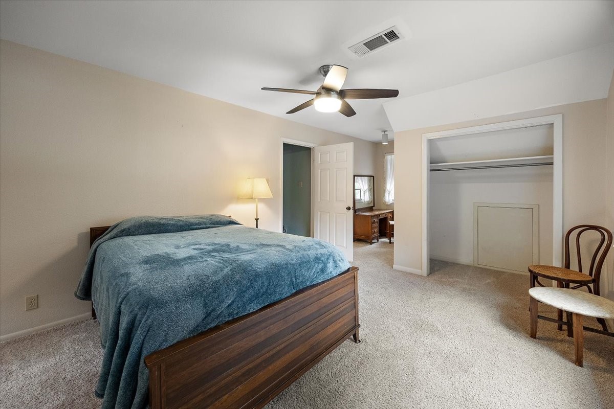 450 Four Notch Road Huntsville, TX 77340 - Photo 20 of 49 a bedroom with a bed and a chandelier