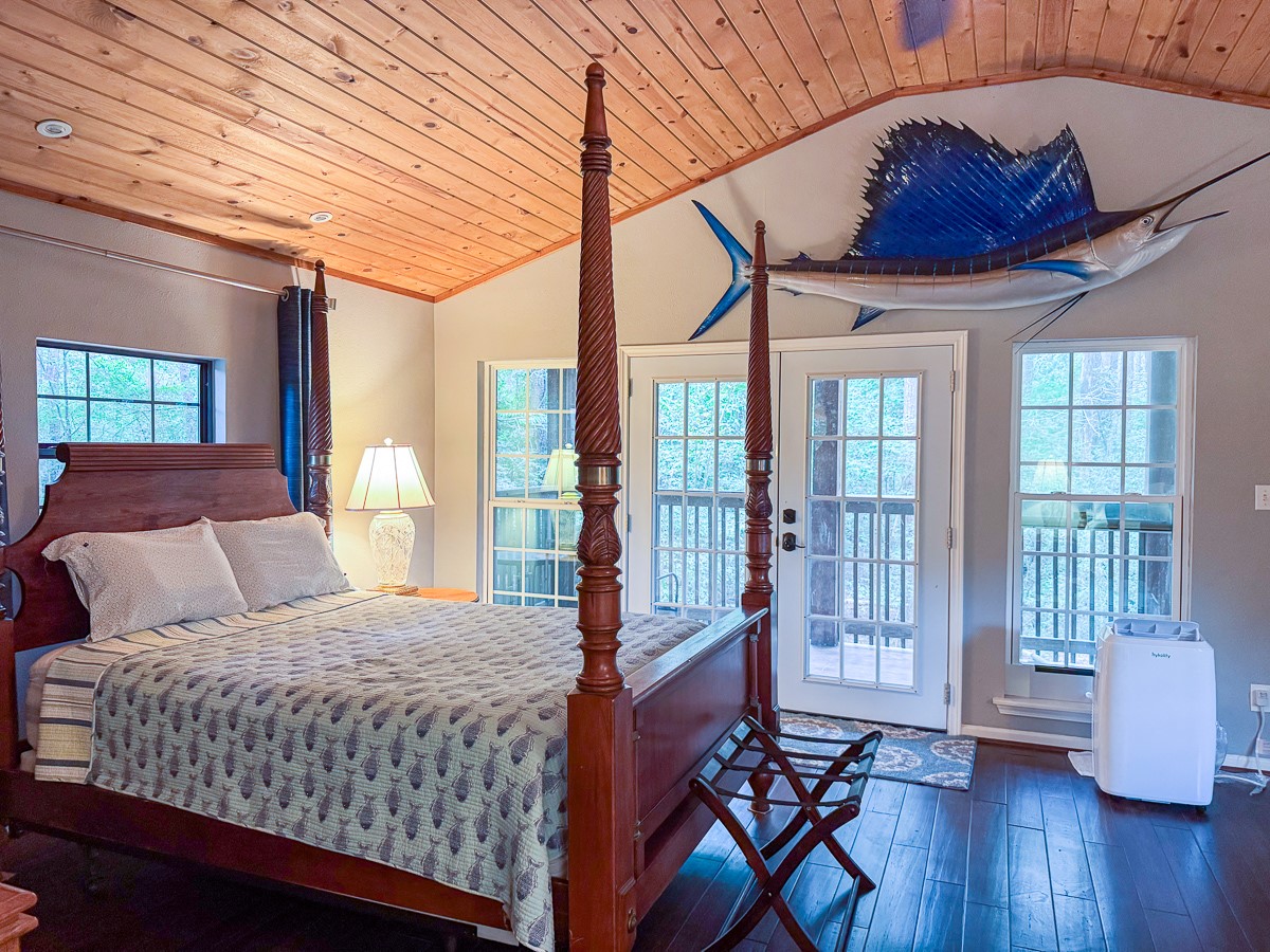 450 Four Notch Road Huntsville, TX 77340 - Photo 29 of 49 a bedroom with a bed and wooden floor