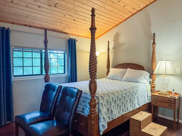 a bedroom with a large bed and windows