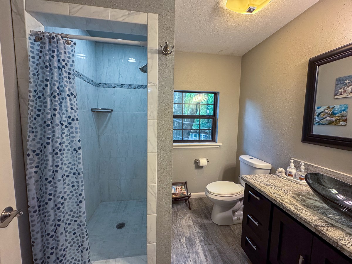 450 Four Notch Road Huntsville, TX 77340 - Photo 34 of 49 a bathroom with a granite countertop sink toilet and shower
