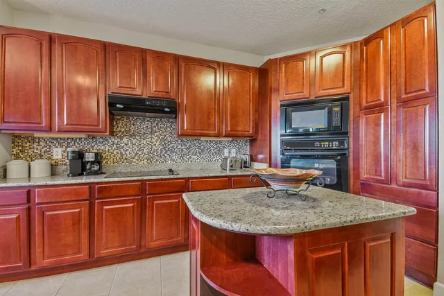 a kitchen with stainless steel appliances granite countertop a stove a sink dishwasher and microwave with wooden cabinets