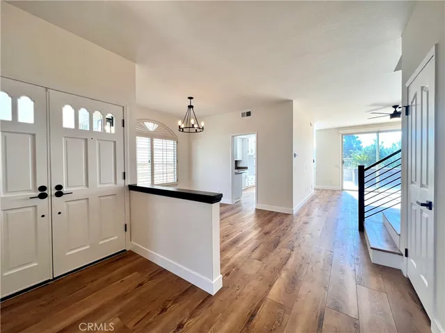 a view of a hallway with wooden floor and staircase