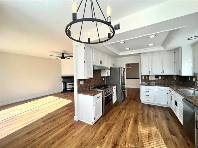 a kitchen with stainless steel appliances granite countertop a stove oven and a wooden floors