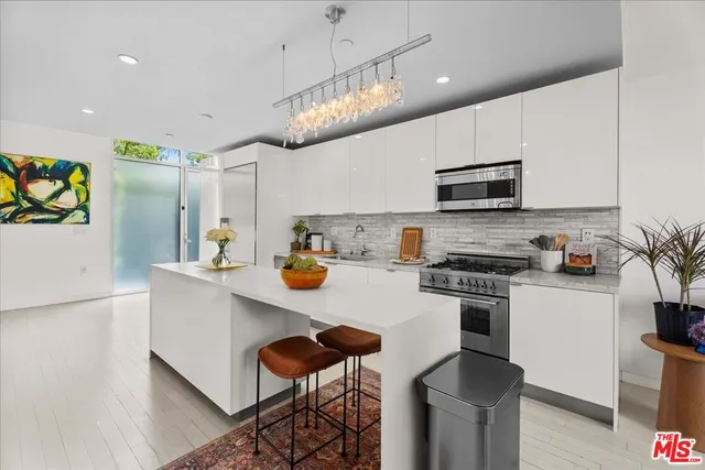 a kitchen with stainless steel appliances a stove refrigerator sink and microwave