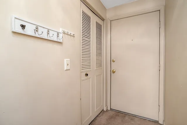 a view of a hallway with a glass door and shower