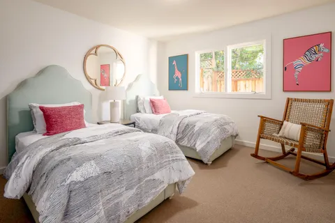 a bedroom with two beds and a window