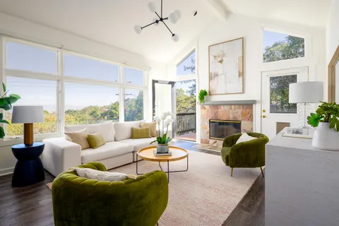 a living room with furniture fireplace and a large window