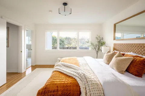 a bedroom with a bed and wooden floor
