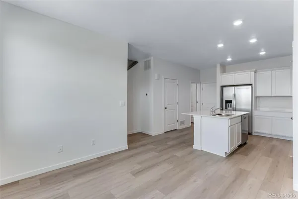 a room with stove and white cabinets