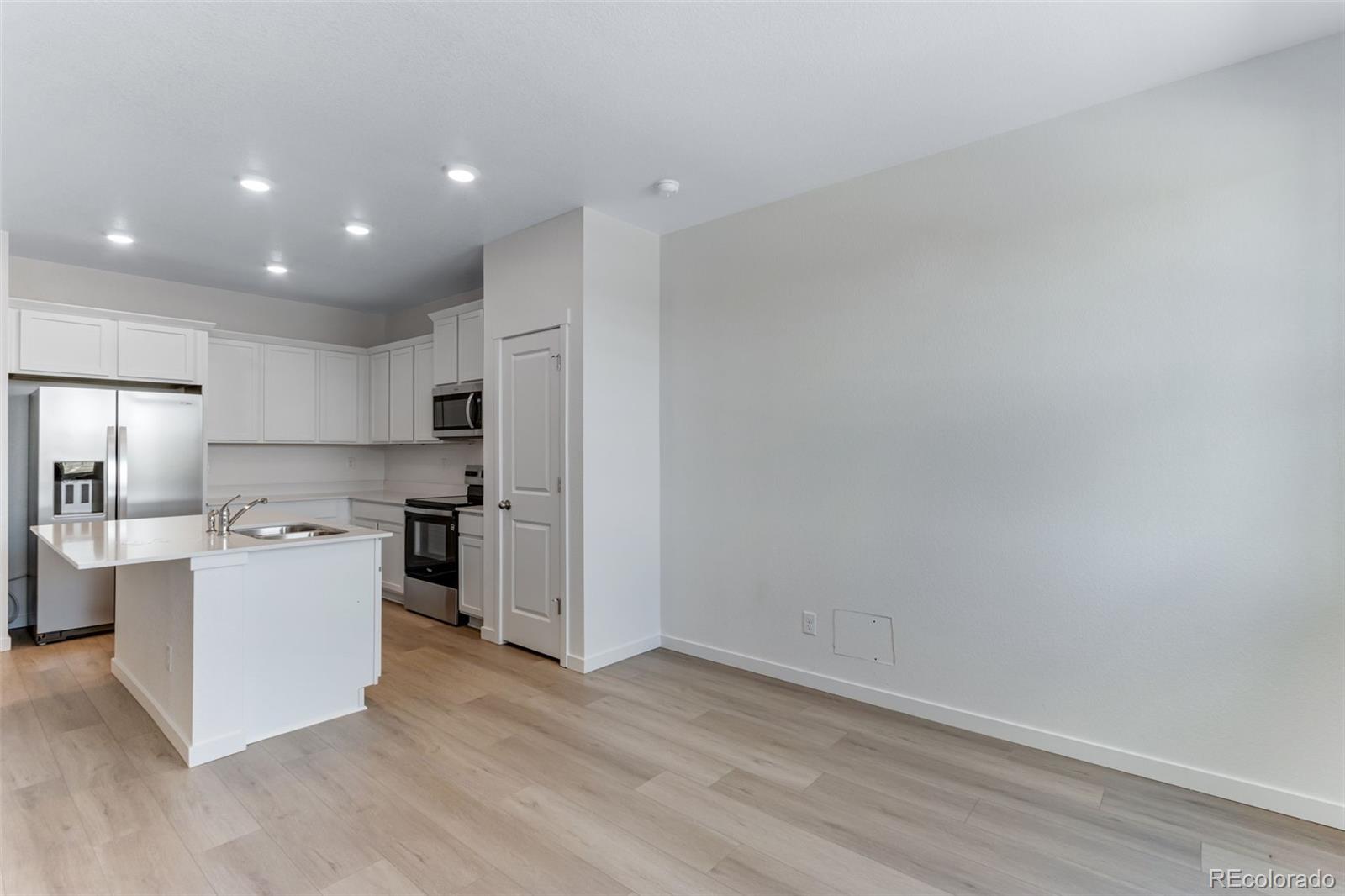 2356 Merlot Street Fort Lupton, CO 80621 - Photo 6 of 24 a kitchen with a sink and refrigerator