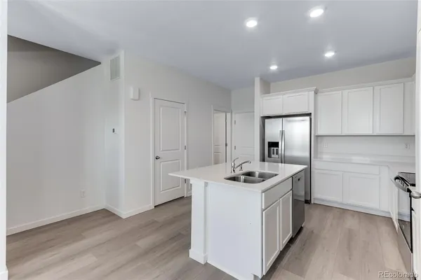 a kitchen that has stainless steel appliances granite countertop a sink stove and refrigerator