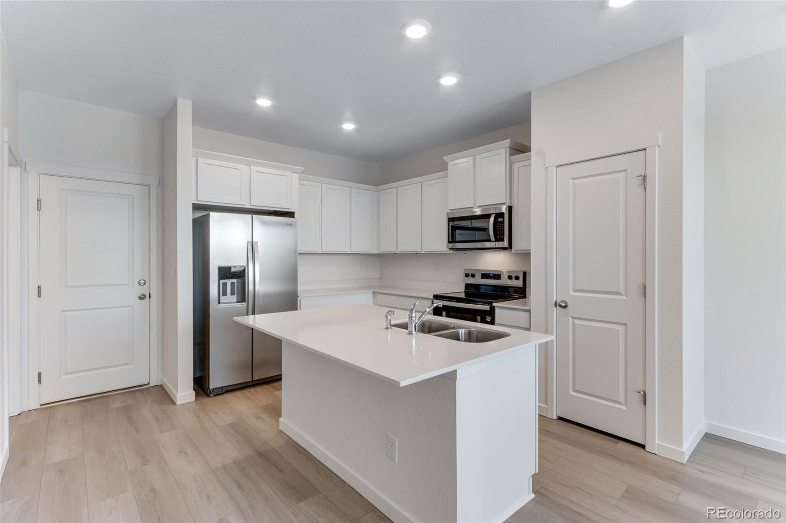 2356 Merlot Street Fort Lupton, CO 80621 - Photo 8 of 24 a kitchen with cabinets stainless steel appliances and wooden floor