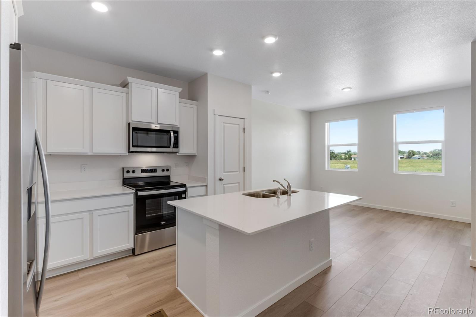 2356 Merlot Street Fort Lupton, CO 80621 - Photo 9 of 24 a kitchen with stainless steel appliances granite countertop a sink stove and refrigerator