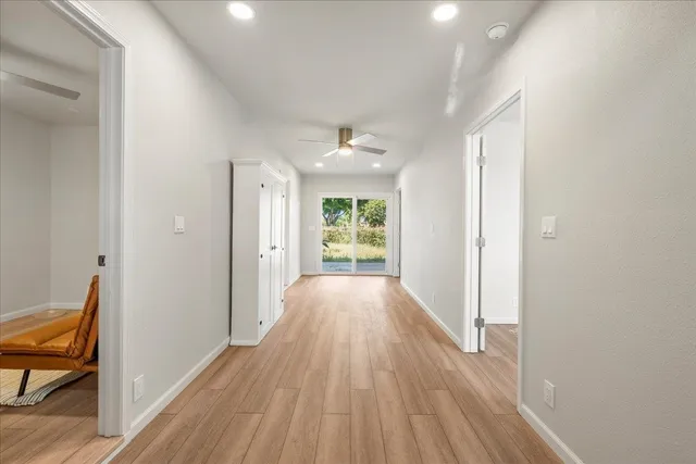 a view of a hallway with wooden floor and a window