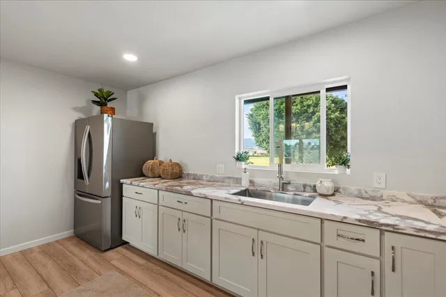 a kitchen with stainless steel appliances granite countertop a refrigerator and a sink