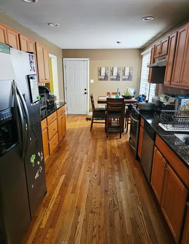 a kitchen with stainless steel appliances granite countertop wooden floors stove and sink