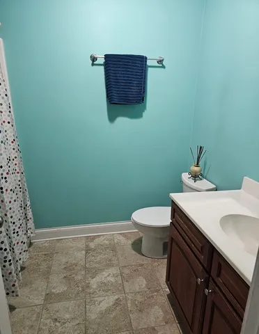 a bathroom with a granite countertop toilet and sink