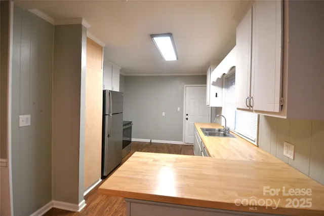 a view of a kitchen with wooden floor and a refrigerator