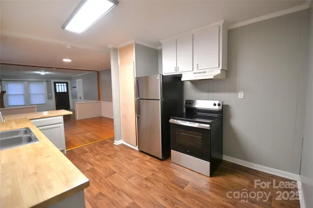 a kitchen with stainless steel appliances granite countertop a refrigerator a stove and a sink