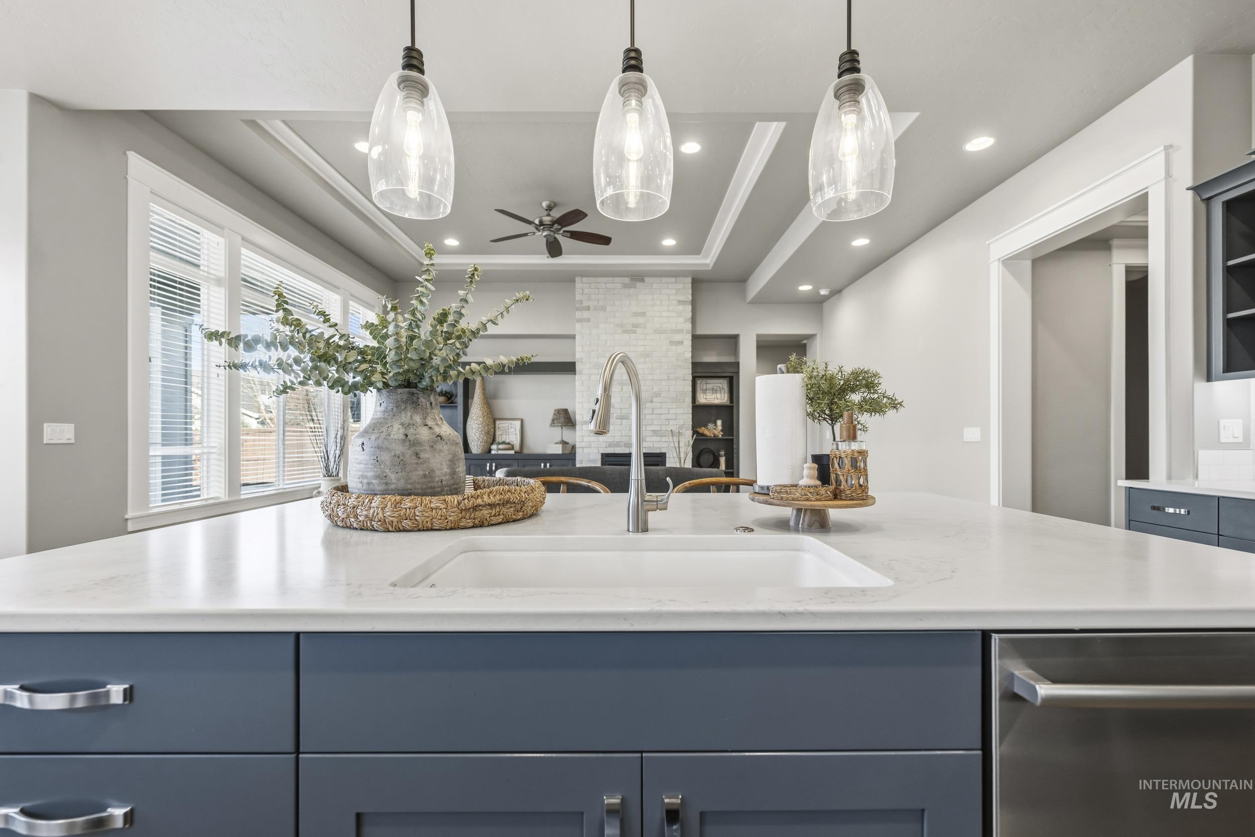 5699 North Fairborn Avenue Meridian, ID 83646 - Photo 11 of 30 Kitchen featuring dishwasher, pendant lighting, a tray ceiling, a ceiling fan, and light stone counters