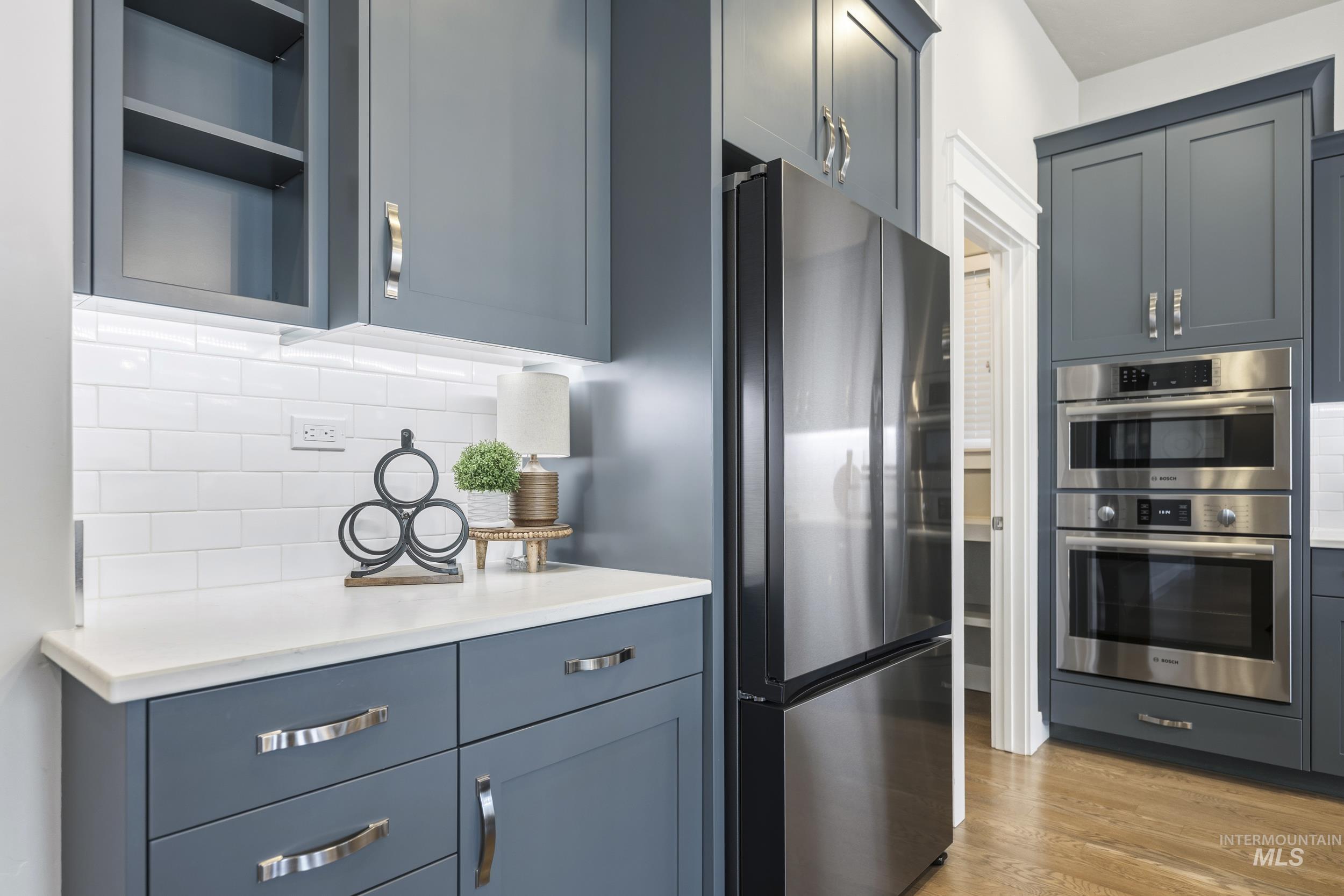5699 North Fairborn Avenue Meridian, ID 83646 - Photo 13 of 30 Kitchen with stainless steel appliances, decorative backsplash, light wood-style floors, and open shelves