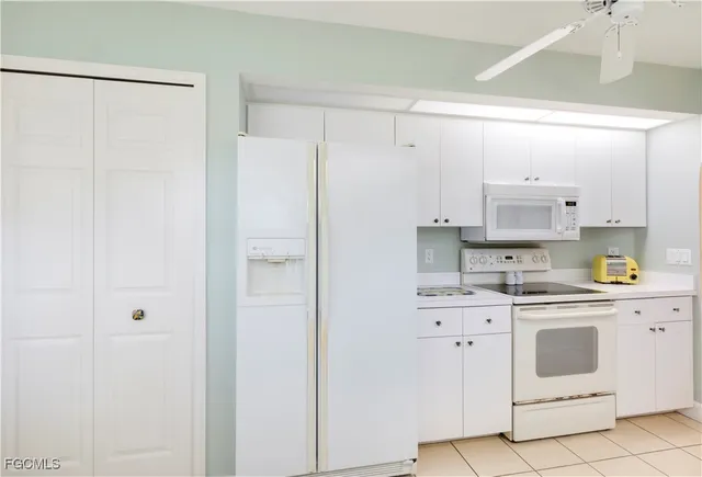 a kitchen with white cabinets and white appliances