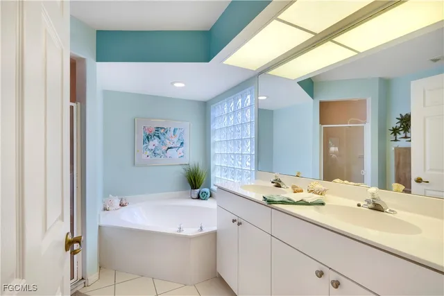 a spacious bathroom with a tub sink and mirror